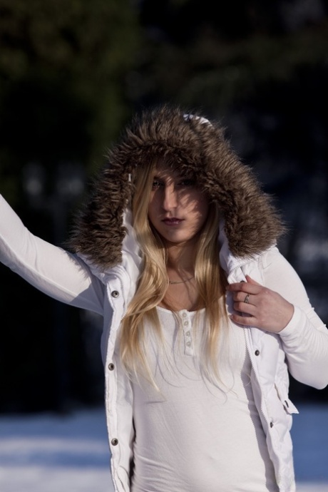 Den blonde jenta Caroline Fox poserer naken i snøen mens hun sprer beina.
