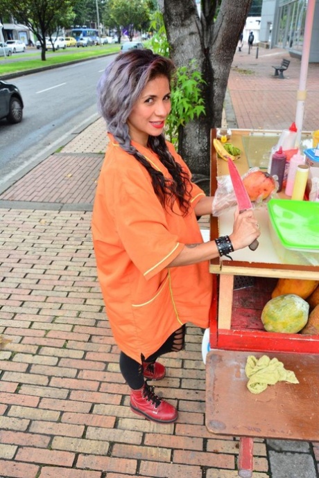 Beautiful Colombian fruit seller gestures provocatively with a banana