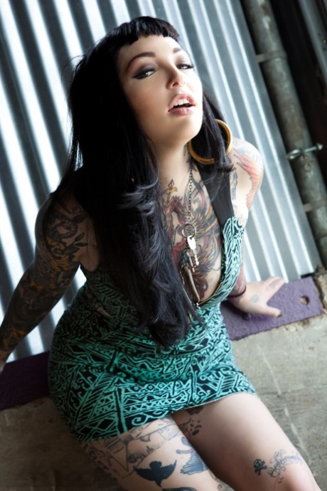 Sexy vriendin met veel tattoos over heet lichaam demonstreert kaal kutje