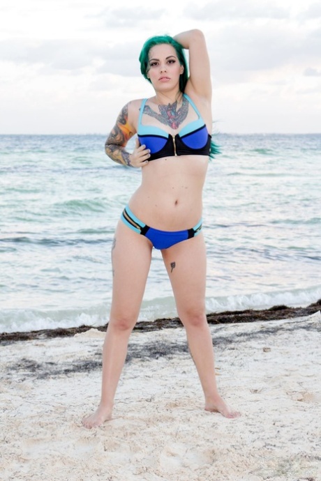 Zielonowłosy plażowicz Taurus odsuwa bikini na bok, aby pokazać gorący tyłek w piasku