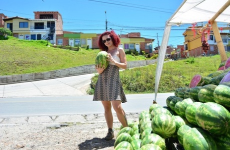 Latina ruiva encaracolada com mamas pequenas e clitóris grande fica nua para comer um melão