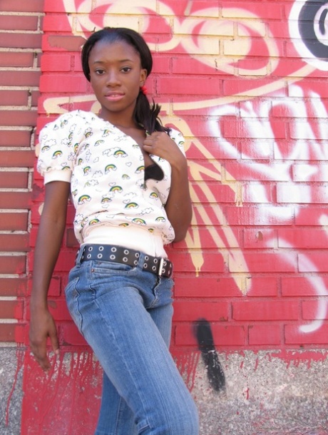 La femme fétichiste Ebony fait un strip-tease dans une ruelle pour montrer ses petits seins et son cul.