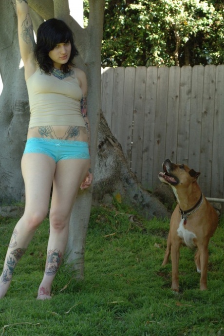 Tattooed punk chick takes her clothes off and poses in the backyard