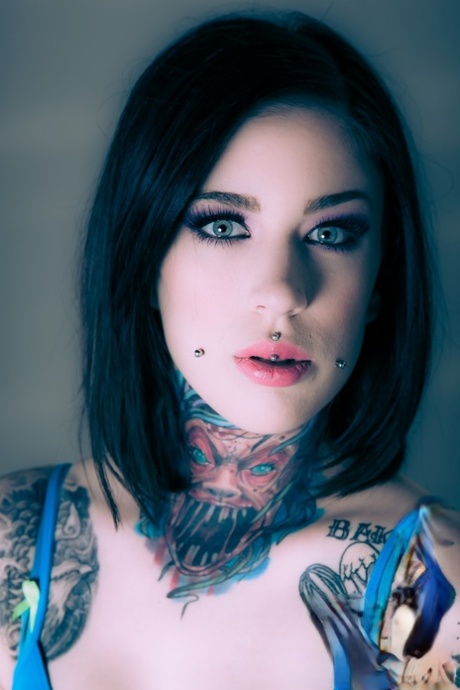 Belle mannequin tatouée Mabel touchant son corps sexy et écartant le cul chaudement