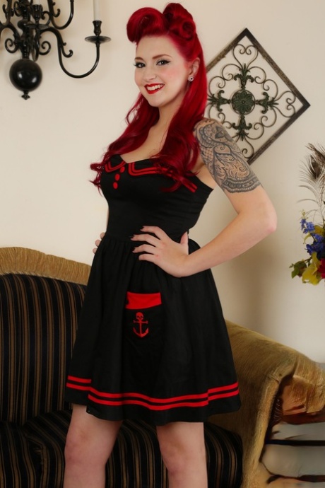 La pin-up sexy Amber Ivy se débarrasse de sa robe de marin pour montrer sa chatte en talons rouges.