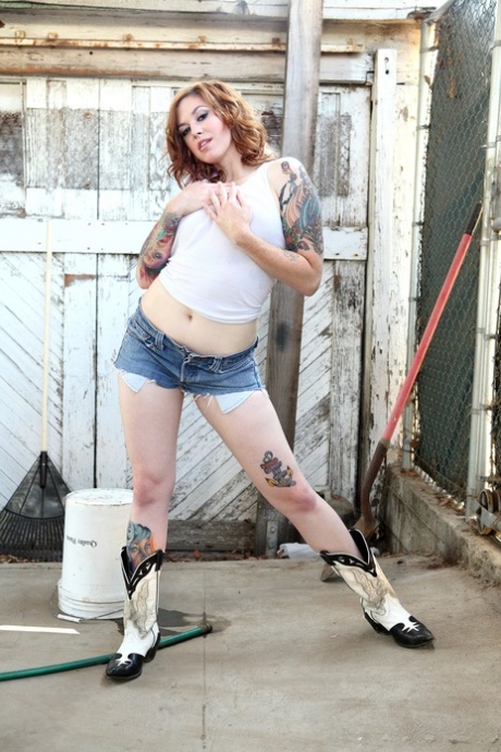 Tatted cowgirl Swindle shows af haar luscious bips en grote, natte Tieten uit terug