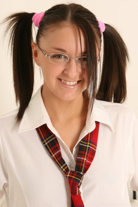 Brunette tiener trekt schooluniform uit tot ze in een string en staartjes zit