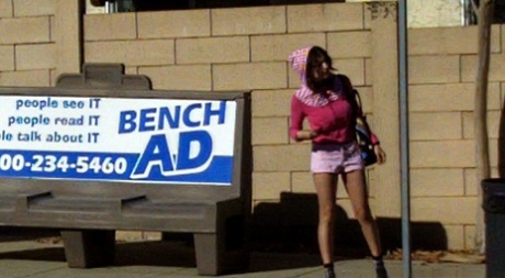 Petite brunette takes off shorts in public en waits voor de bus in ondergoed