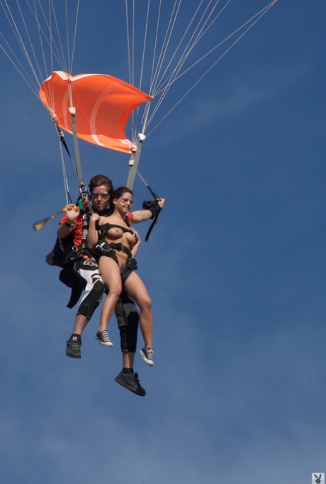 Des mannequins aux courbes étonnantes s'amusent nus sur des tyroliennes et des parachutes.