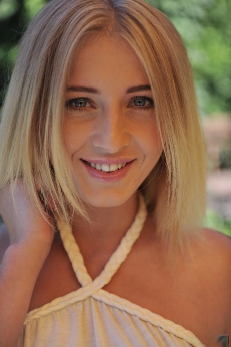 Den blonde tenåringsbaben Aria Logan kler seg naken i hagen og viser fitta.