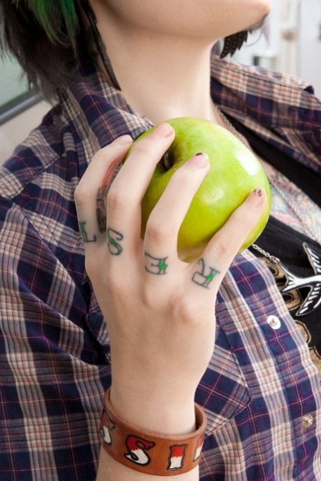 Weißes Küken Miss Genocide isst einen Apfel, während sie sich auszieht