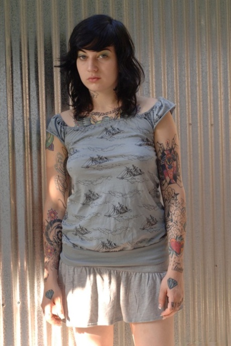 Tattooed emo girl hikes dress to reveal alluring ass & meaty bald pussy