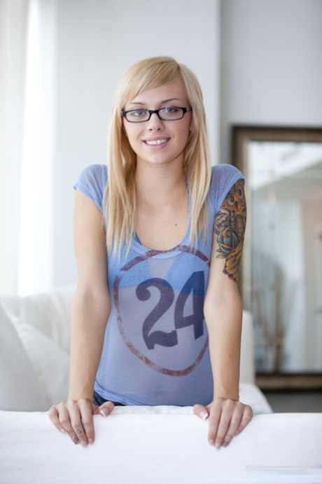 Young blonde cutie Emma Mae in glasses sheds her clothes to spread bald pussy