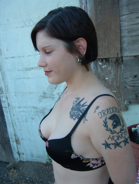 Süßes Emo-Küken mit Tattoos bedeckt zeigt ihren Arsch in schwarzen Strümpfen