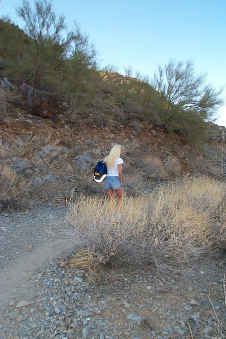 Blondynka Kelly Erikson eksponuje swoje duże sztuczne cycki na skalistej górze