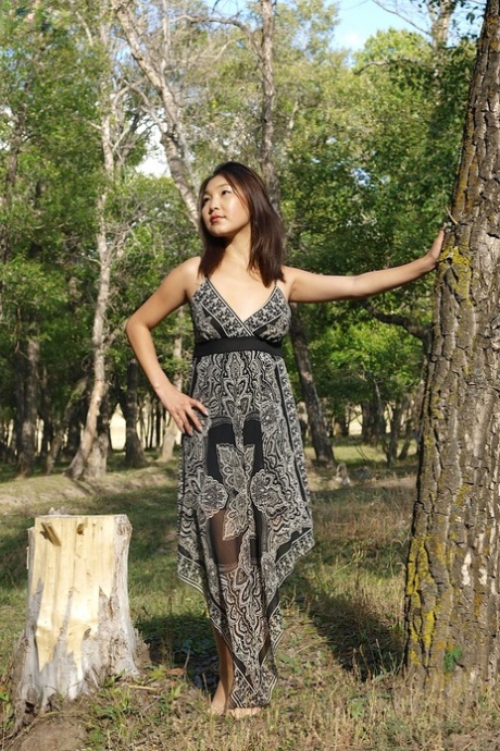 Gulnaz, une jeune femme asiatique aux petits seins, exhibe ses seins dans le parc.