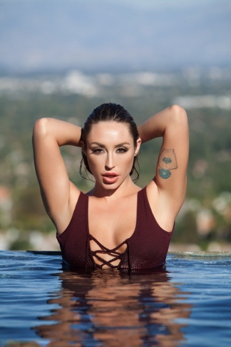 La guapísima modelo Christiana Cinn se pela el bañador para asolear sus tetas naturales en el agua