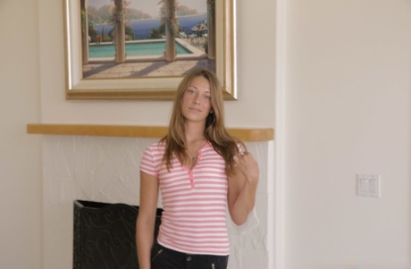 Den søte amerikanske tenåringen Kirsten Lee stripper og poserer naken i stuen.
