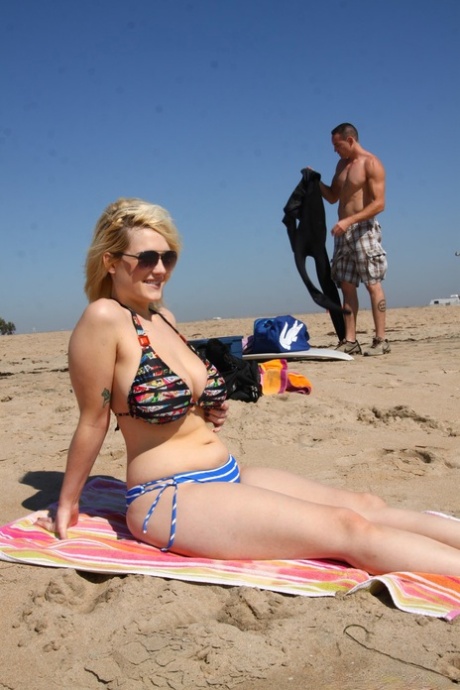 Пухленькая блондинка Сири выставляет напоказ свои большие сиськи в бикини на пляже