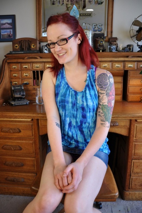 Roodharige met bril en tatoeage Jenn Seven onthult haar lichaam in een solo