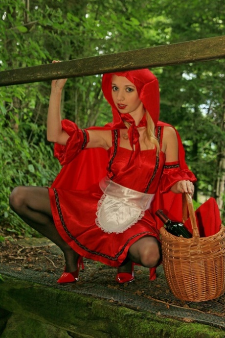 Blonde tiener in Roodkapje-kostuum Kayla stript in het bos