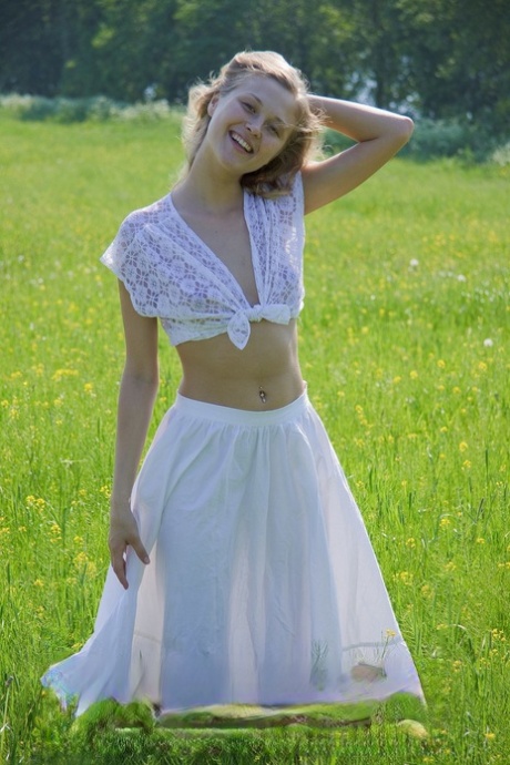 Amateur beauty Darya loses her white outfit and rubs her muff in the field