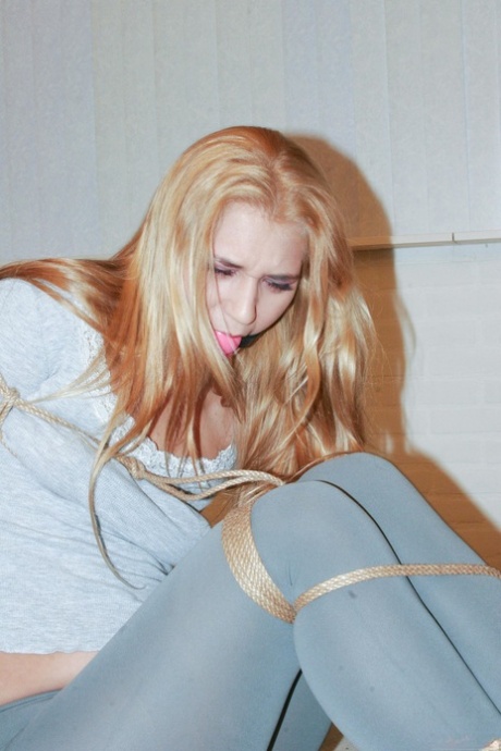Blondýnka v horkých punčochách Linda Ray se snaží osvobodit z roubíku a provazů