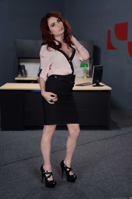 Den rødhårede sekretæren Ashley Graham skreller av sexy undertøy for å vise frem en trimmet fitte.