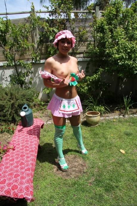 Seksowna mała pokojówka w uroczym mundurku rozkłada swój ciasny tyłek na zewnątrz w ogrodzie