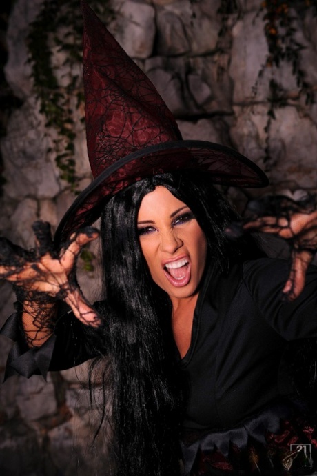 Dark haired witch Sandy shows her trimmed pussy and drills it with a broom