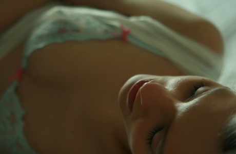 Den platinablonde tenåringen Kira W tar av seg undertøyet og står naken på soverommet.