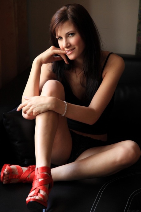 Den brune modellen Lauren Crist tar av seg det svarte undertøyet og de røde høyhælte skoene mens hun poserer.
