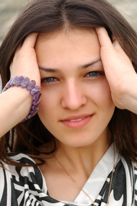 La bellezza adolescenziale Sofi A mostra le sue grandi tette mentre posa in calze a rete sulla spiaggia