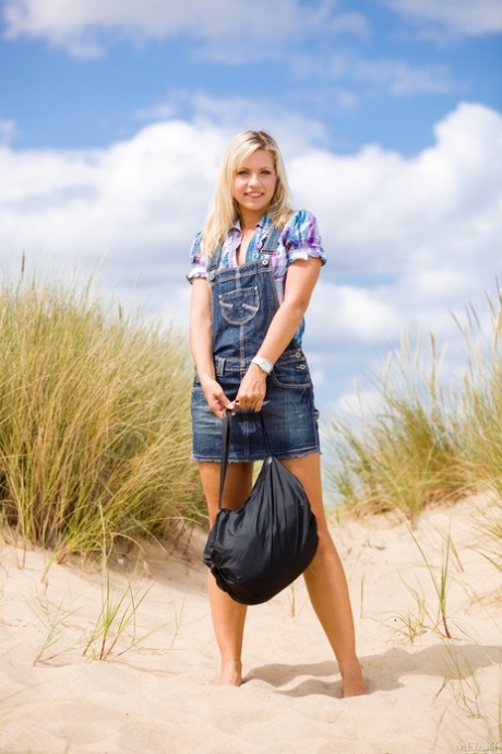 Blonde tiener Jenni A toont haar dikke kont en kleine tieten op het strand