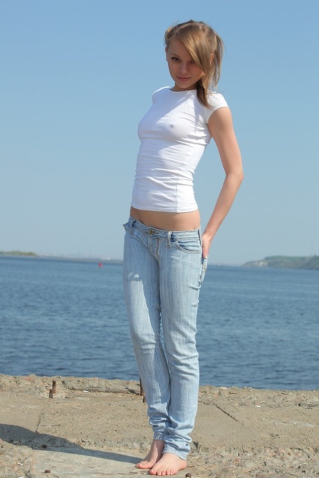 Hot teen with a slim body Avril B reveals her cute titties by the sea