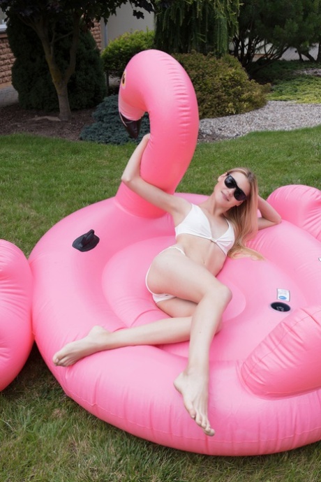 Celestine, uma adolescente glamorosa, a posar nua num flutuador flamingo
