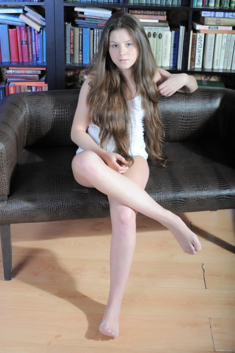 A adolescente de cabelo comprido Malina B despe-se e posa nua na biblioteca