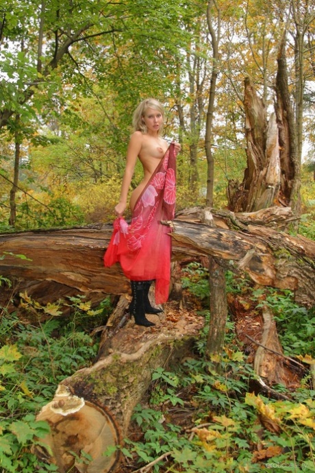 Glamorous teen babe Koika strips to her leather boots in the forest