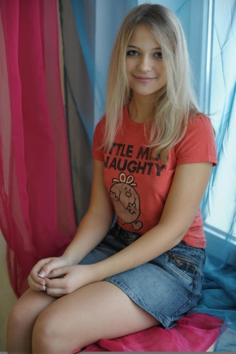 Słodka blond nastolatka Natja rozbiera się przy oknie w swobodny sposób