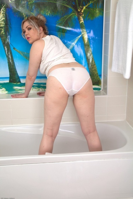 Krátká zralá blondýnka Daisy Woods ukazuje své kalhotky a chlupatou kundu ve vaně