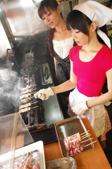 Aziatische kok Akubi Yumemi wordt in haar muil genomen terwijl ze aan het grillen is