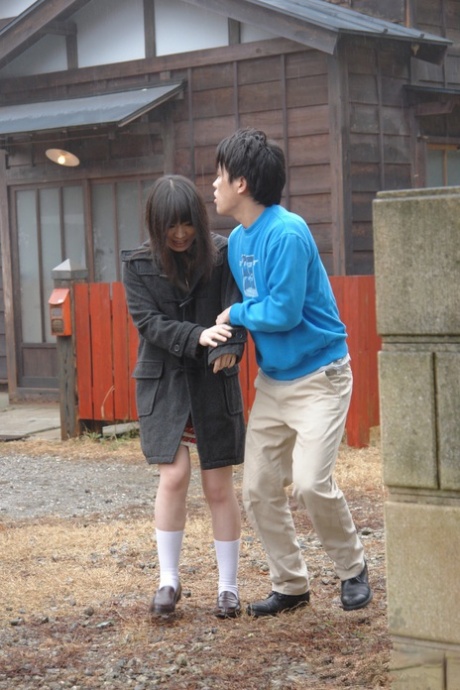 Den asiatiske kjære Mai Shimizu kneler foran en mann og runker utendørs.
