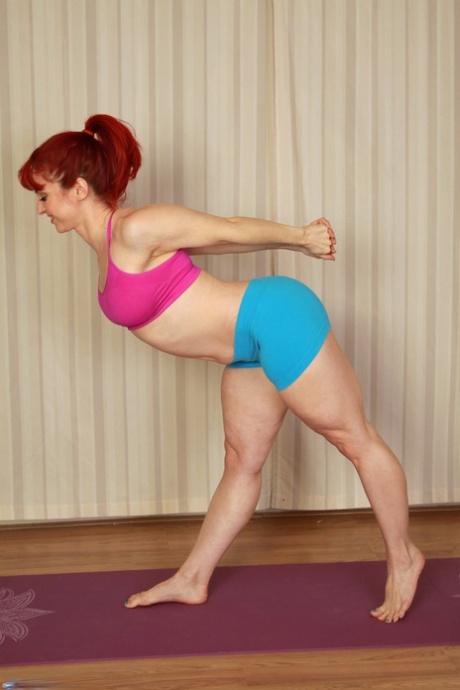 灵活的生姜安德烈娅-罗苏在瑜伽垫上脱光衣服，展示自己的身体