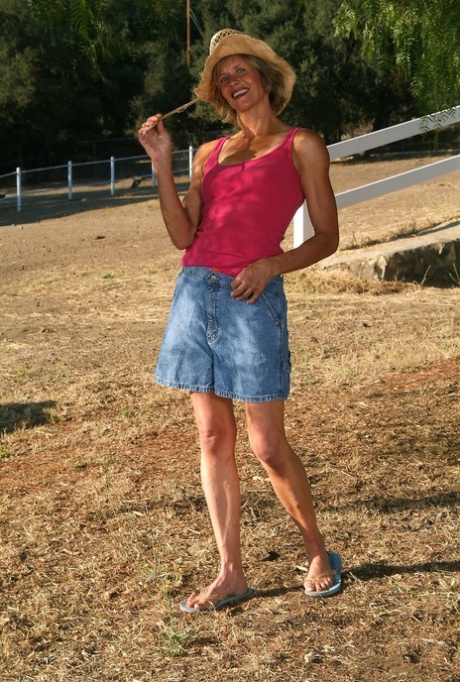 Skinny mature Carmen F loses her shirt and denim skirt to pose naked outdoors