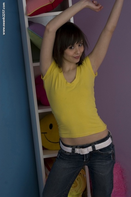 Petite MILF Ariel Rebel posando en su camisa amarilla y jeans ajustados