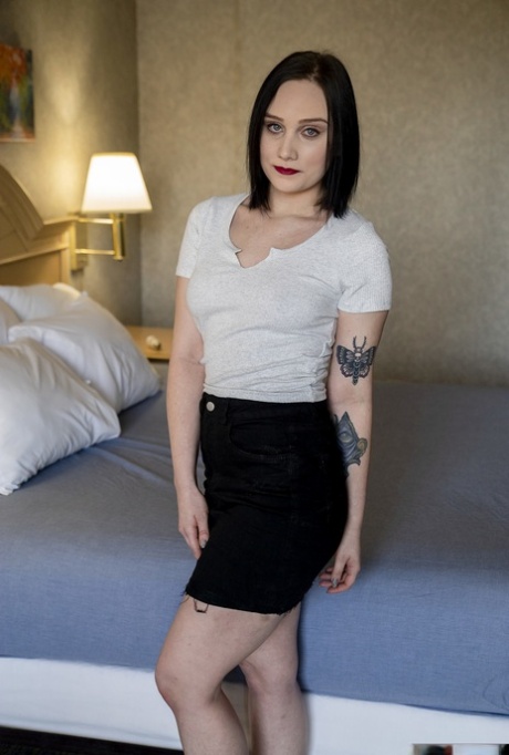 A adolescente sexy com tatuagens Gwen Vicious despe-se e esfrega a vagina numa cama