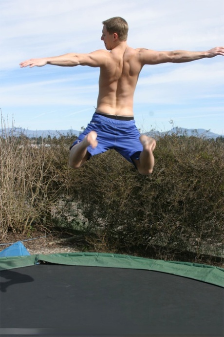 Gay cachondo con un buen culo Tommy D se desnuda y salta en un trampolín