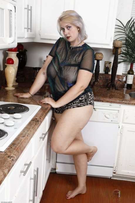 Busty blonde housewife Nyx Night shows her hairy vagina in the kitchen