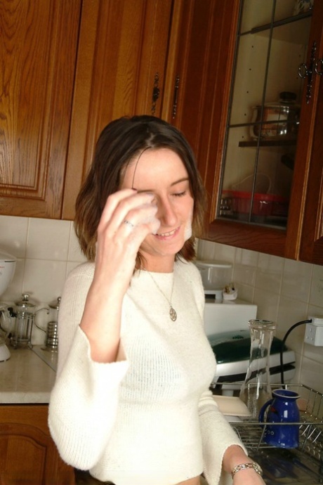 Gina, jeune femme au foyer britannique, se déshabille devant son homme dans la cuisine