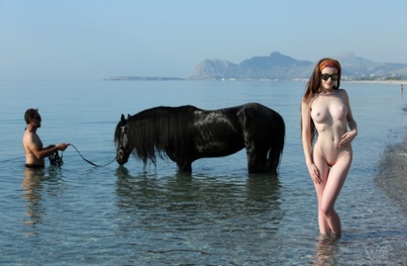 Den sexy europeiske modellen Emily viser frem store pupper og fitte mens hun rir på en hest.